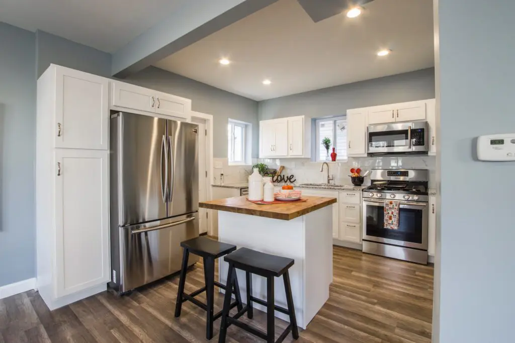 Large kitchen with a clean stainless steel microwave. Large kitchen with a clean stainless steel microwave, refrigerator and stovetop.